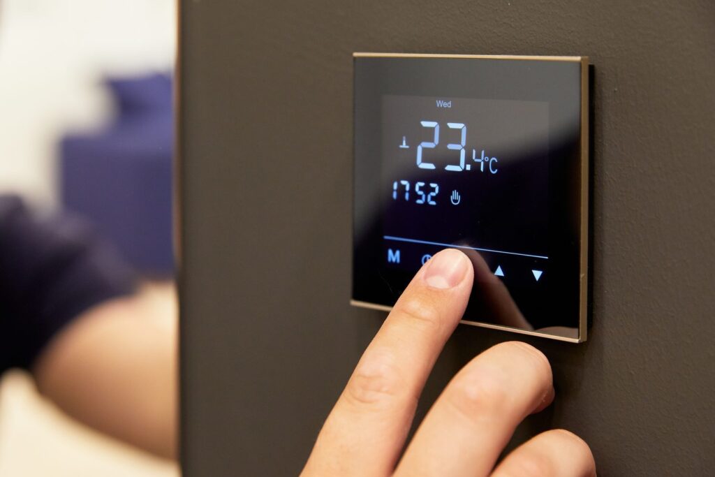 Réglage d'un thermostat digital mural affichant la température
