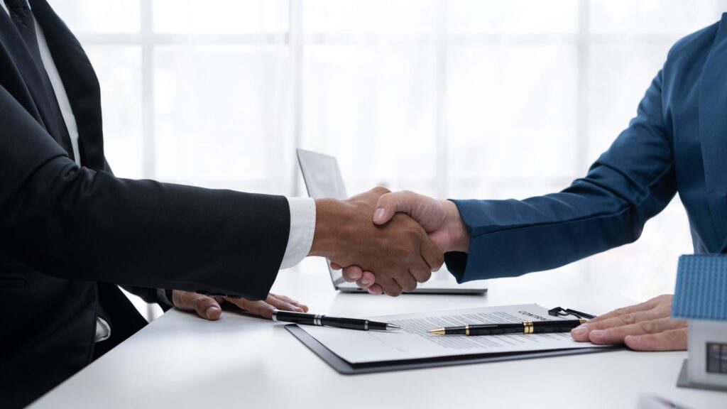 Poignée de main entre deux partenaires après la signature d'un contrat