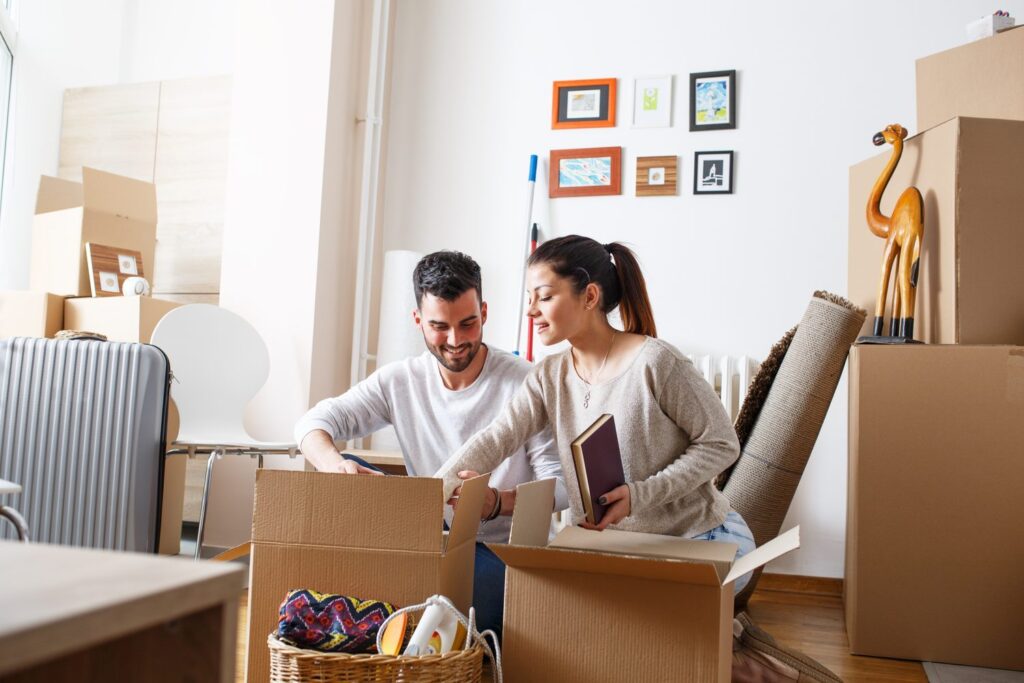 Un couple souriant en train de déballer des cartons de déménagement