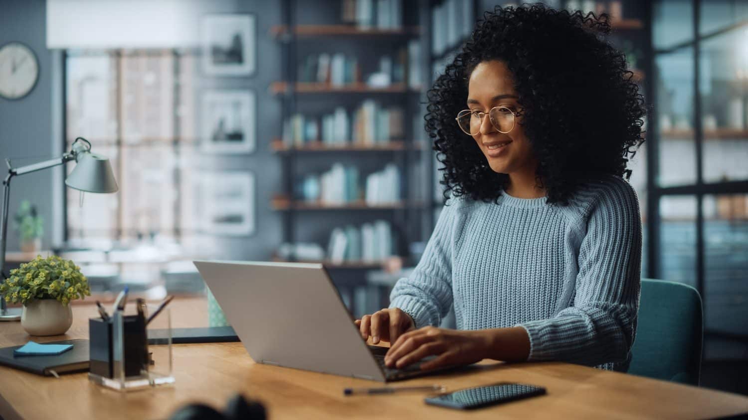 Une femme travaillant sur son ordinateur portable dans un bureau à domicile
