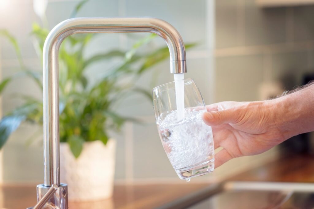 Un verre rempli d'eau au robinet dans une cuisine moderne