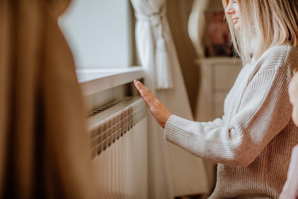 Une main posée sur un radiateur pour vérifier la chaleur