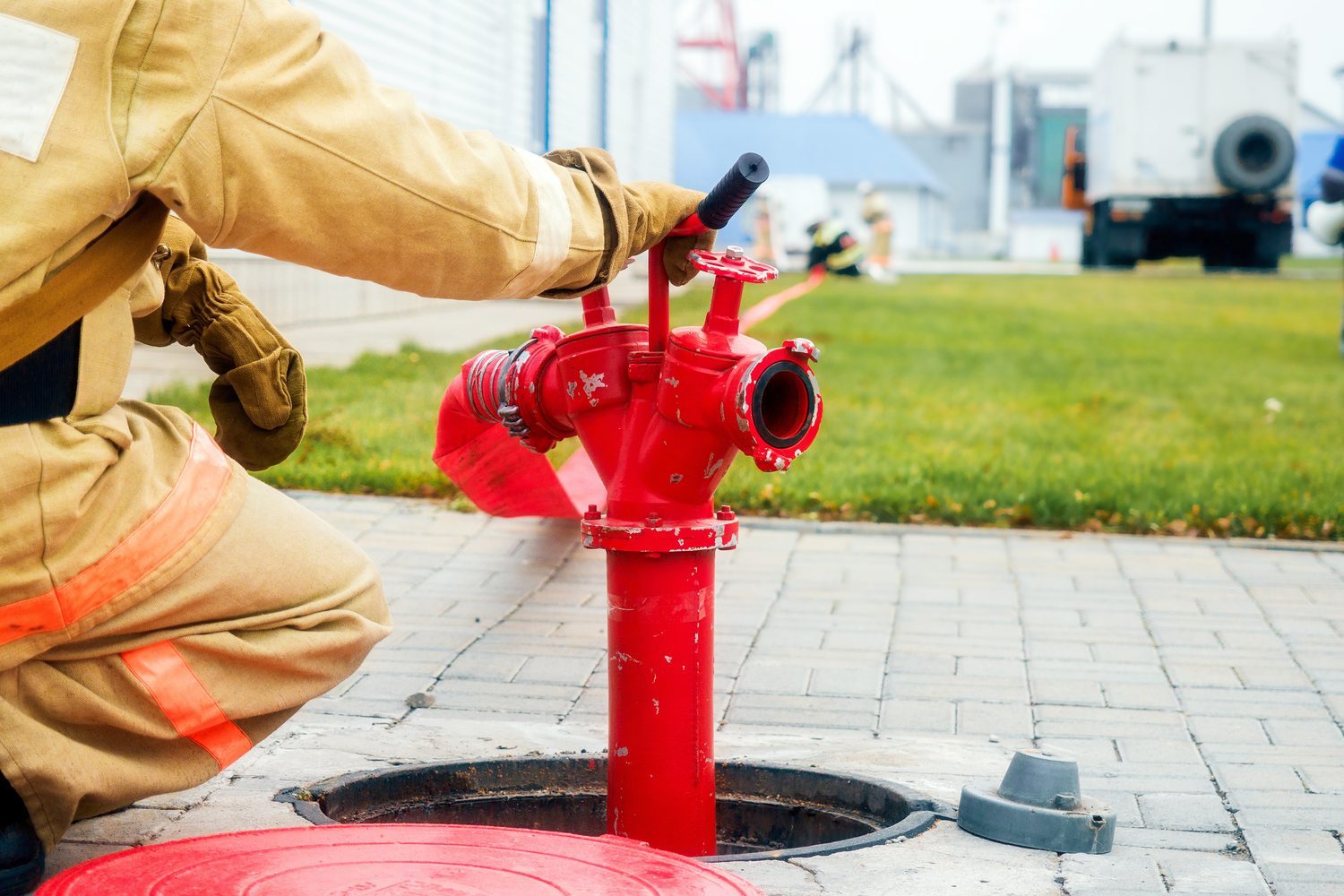 Un pompier ouvrant la vanne d'un poteau incendie
